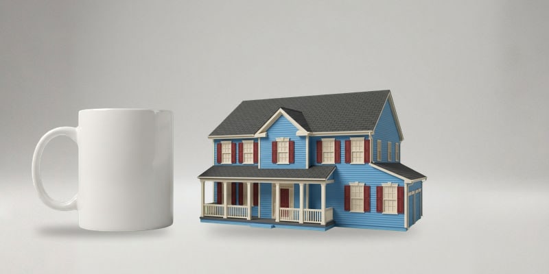 The large multicolor house keepsake next to a coffee mug for scale