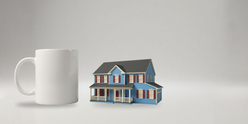 The medium multicolor house keepsake next to a coffee mug for scale